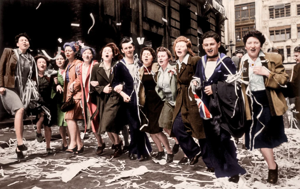A colour photograph of Sailors and ladies dancing in the streets