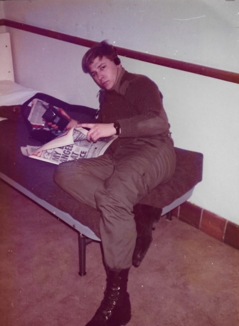 A picture of Brett Portman REME on a bed reading a paper in Northern Ireland 