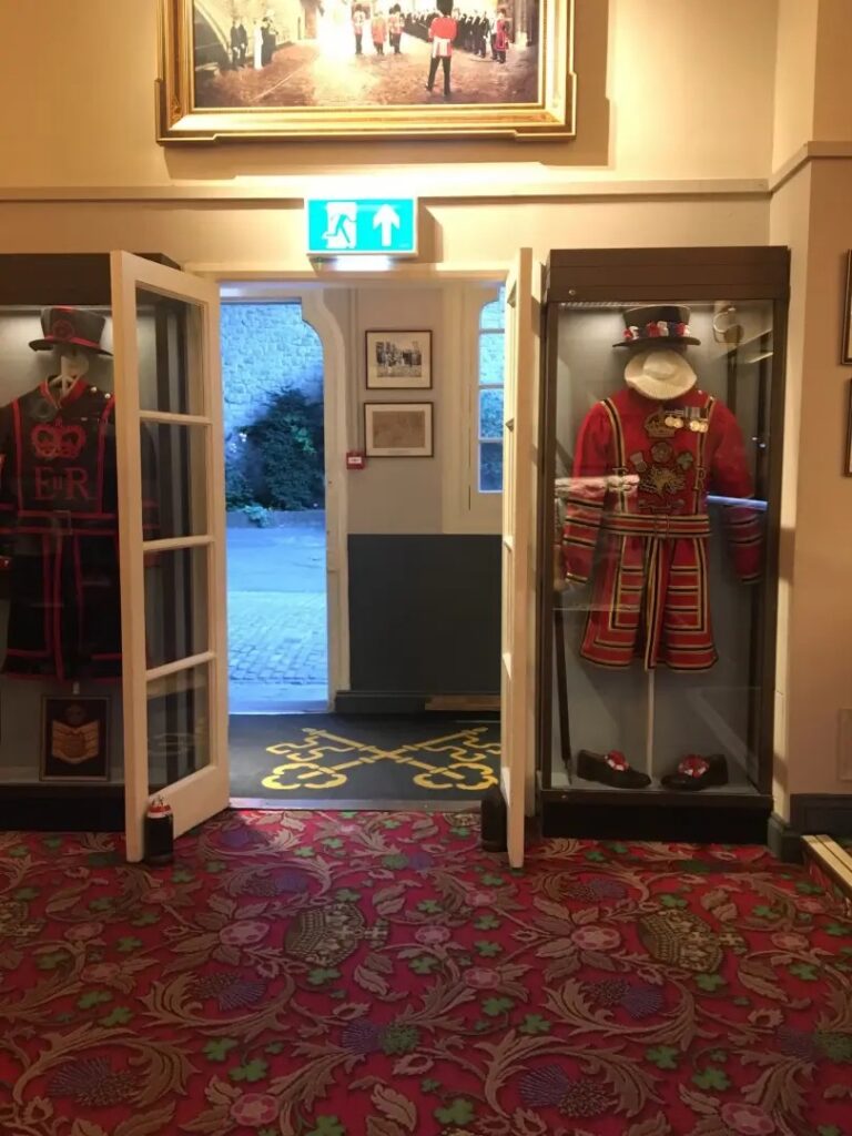 A picture of the inside of the keys pub showing two display cabinets each housing a yeoman uniform. 